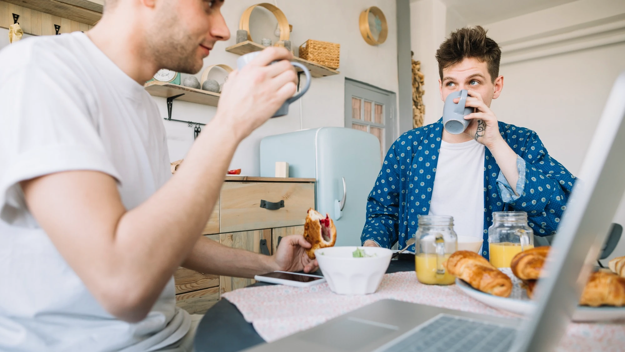 Deux adultes prennent un repas et des boissons devant un ordinateur